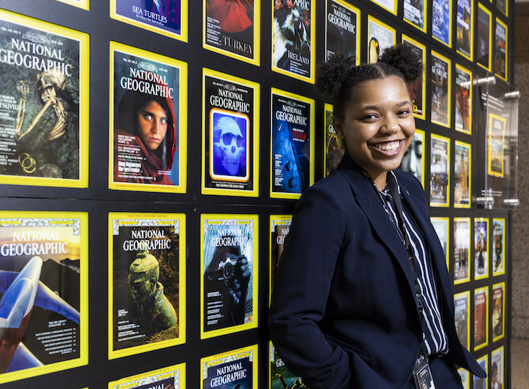 young woman standing in front of National Geographic covers